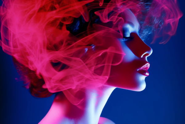A woman with striking red hair is featured in this image, with wisps of smoke elegantly swirling around her head. The woman''s hair appears to be enveloped in a pink cloud of smoke, creating a mesmerizing and ethereal effect. The background is a mix of deep blue and red hues, adding to the dramatic and mysterious atmosphere of the image. The woman''s expression is not visible, but her presence exudes a sense of confidence and allure. The overall composition is visually captivating, with a perfect balance of color and movement
