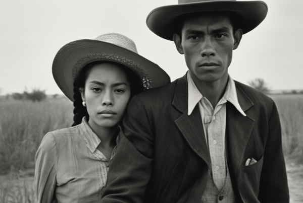 In this black and white photo, we see a man and a woman standing in a field. The man is wearing a suit and a hat, while the woman is also wearing a hat. The man appears to be in his thirties and is standing on the left side of the image. The woman, who looks to be in her twenties, is standing on the right side. The man''s hat is a sun hat style, while the woman''s hat is a more traditional style. The background consists of a vast field, creating a serene and peaceful atmosphere.