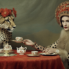 In this image, a woman wearing a leopard costume is sitting at a table with a leopard. The woman is also wearing a hat and is holding a tea cup. The table is covered with a red tablecloth, and there are plates, a tea pot, a bottle, and a cup on the table. The woman''s outfit resembles that of a cheetah, and she is surrounded by a black and white color scheme. Additionally, there is a polka dot dress and a fur collar visible. The woman appears to be in her late twenties and is of female gender
