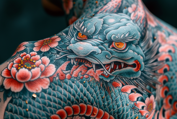 A man with a dragon tattoo on his back is featured in the image. The tattoo depicts a detailed dragon with a red eye. The man''s back is prominently displayed, showcasing the intricate design of the tattoo. The colors of the tattoo include shades of blue, red, and brown. The man has his arms by his sides, emphasizing the tattoo on his back. The background is blurred, drawing attention to the central focus of the image - the dragon tattoo. The man appears to have a strong and muscular build, adding to the overall aesthetic of the tattoo.