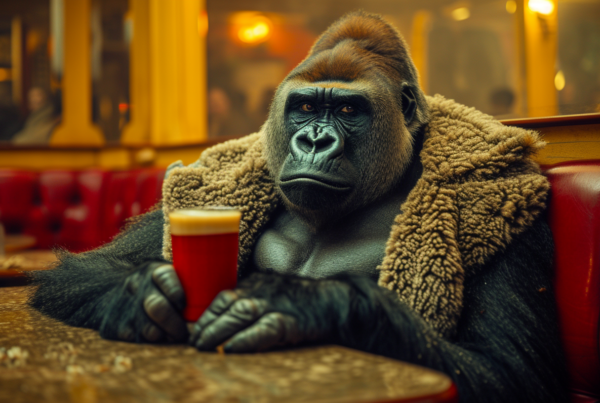 In this image, we see a gorilla sitting at a table, holding a cup of beer in its hand. The gorilla is wearing a brown coat and appears to be enjoying its drink. The table also has a bottle on it, and there is a red cup with a yellow rim placed next to the gorilla. The setting seems cozy, with warm colors dominating the scene. The gorilla''s hands and claws are visible, adding to the realism of the moment. Overall, it portrays a whimsical and amusing scene of a gorilla enjoying a drink at a table